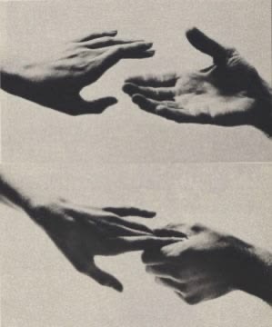 Two hands reaching toward each other and then gently held, in soft black and white